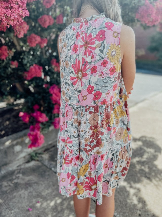 Back of pink Floral ruffle mini dress with pickets and front tie detail